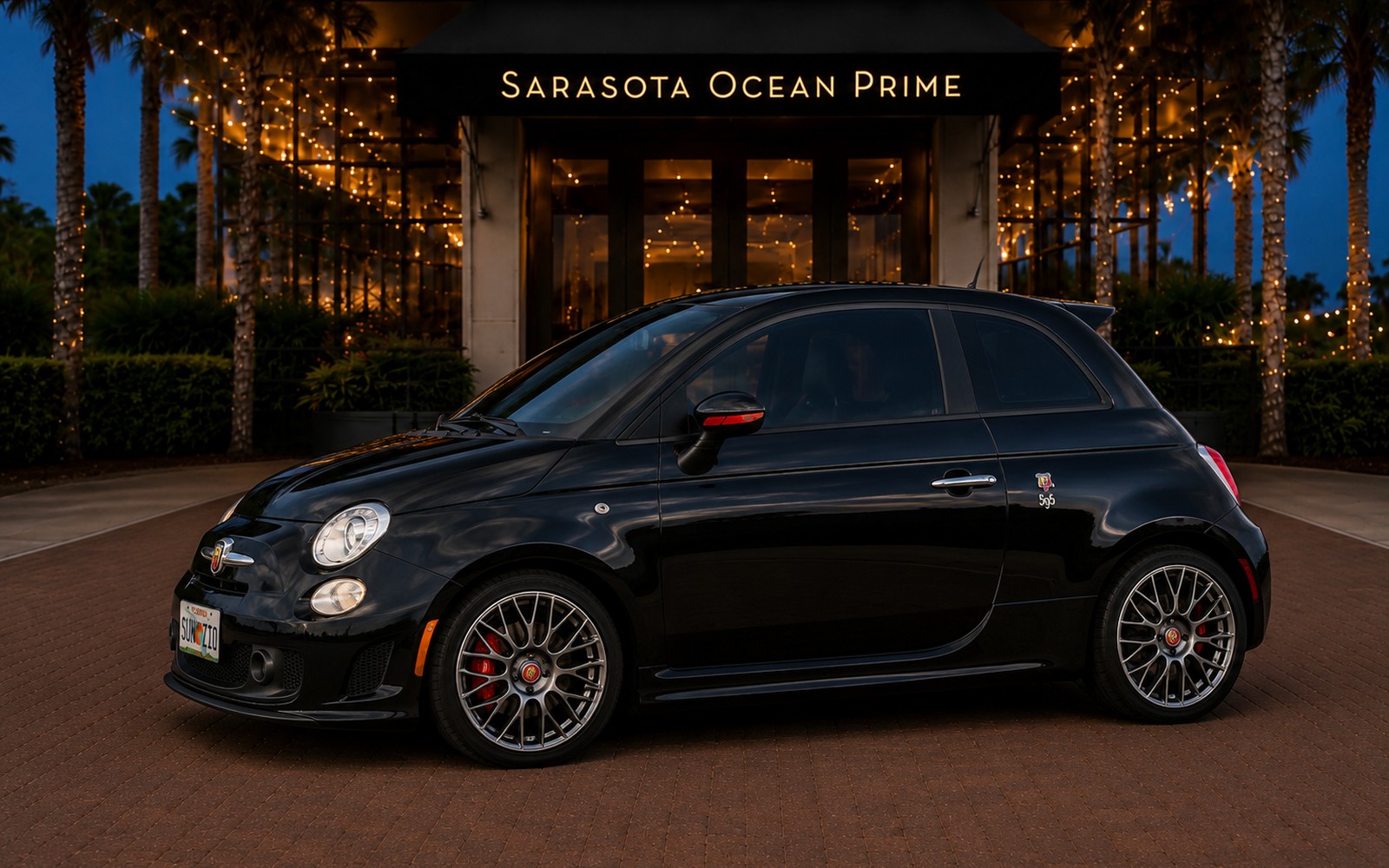 Black 2016 Fiat 500 Abarth espresso rental parked at Sarasota Ocean Prime in the evening